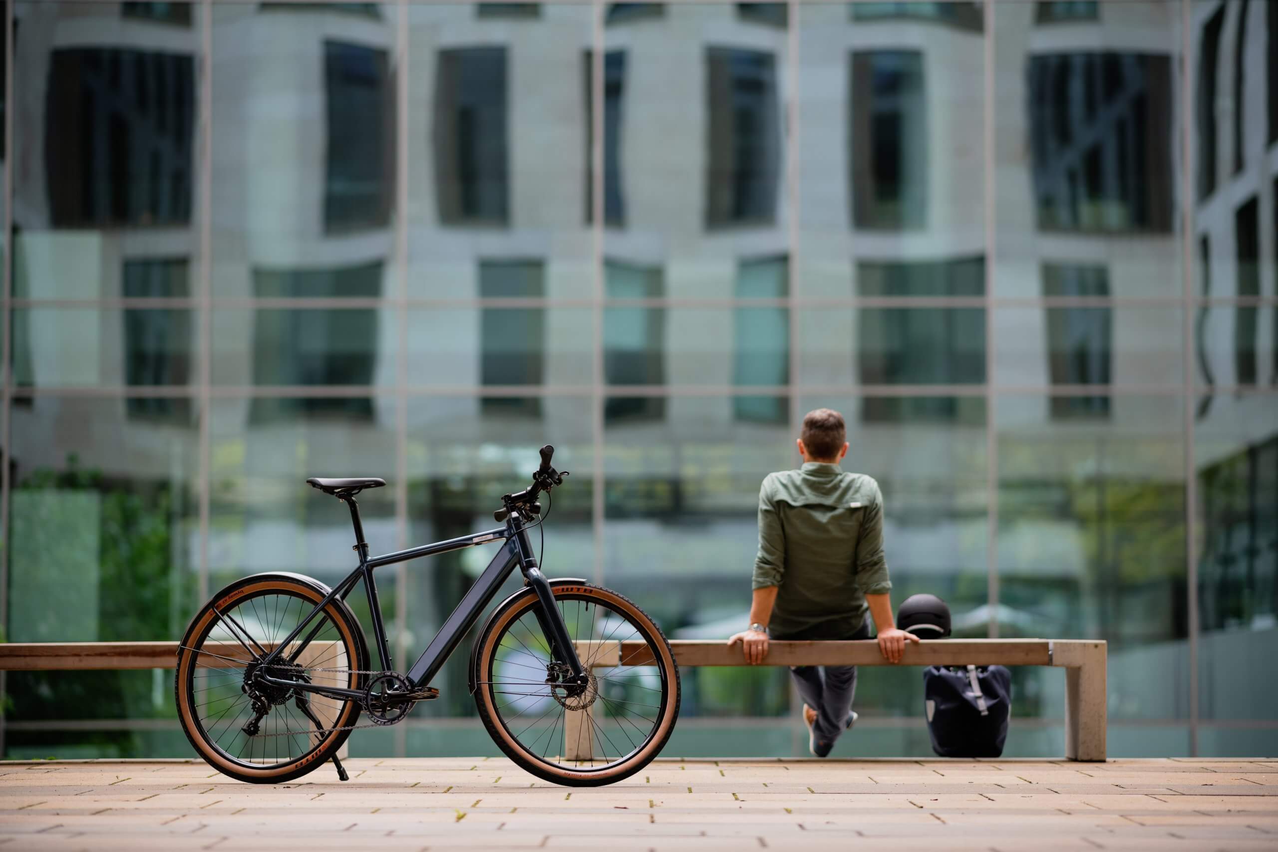 Mann sitzt auf Bank hinter E-Bike Coboc Merano