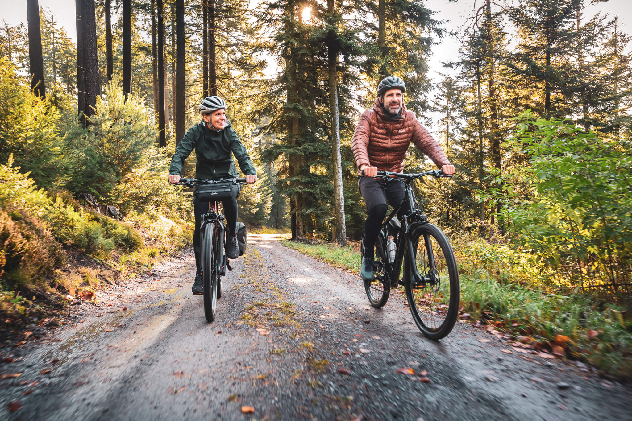 Zwei Männer fahren mit dem leichten Trekking E-Bike Coboc Iseo durch einen Wald